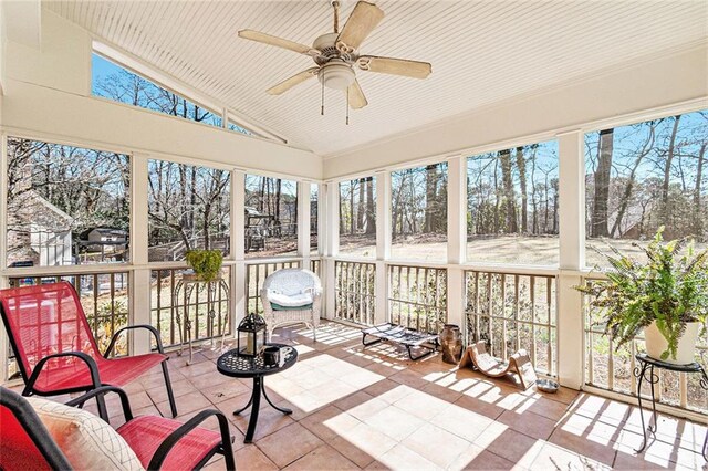 sunroom with vaulted ceiling and a ceiling fan