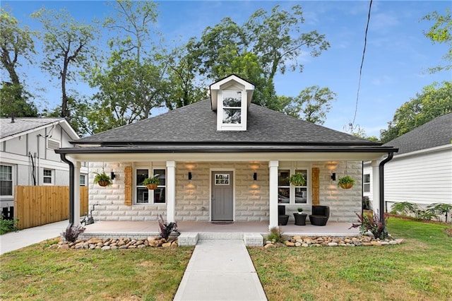 view of front facade with a front yard and covered porch