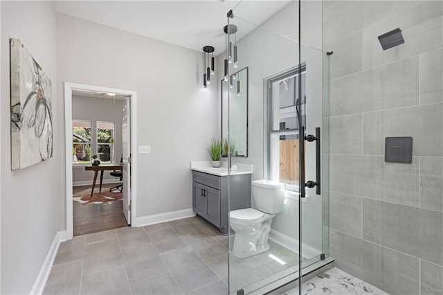 bathroom with toilet, tiled shower, and vanity