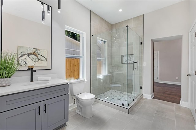 bathroom with toilet, a shower with door, vanity, and tile patterned floors