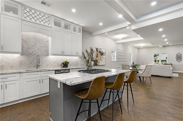 kitchen with a kitchen island, white cabinets, and light stone counters