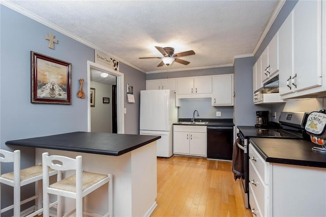 kitchen with black dishwasher, freestanding refrigerator, electric range, dark countertops, and a sink