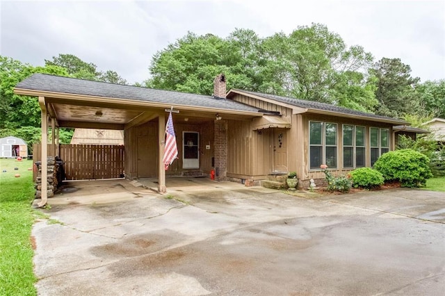 view of front of house featuring a chimney, driveway, and a carport