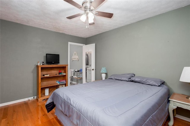 bedroom with light wood-type flooring, baseboards, a textured ceiling, and a ceiling fan