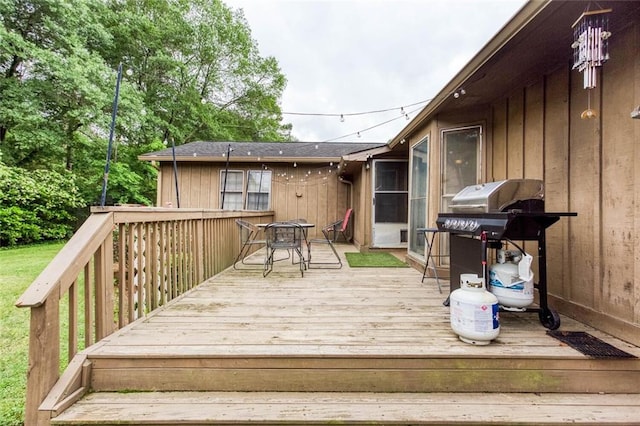 wooden deck featuring a grill and outdoor dining space