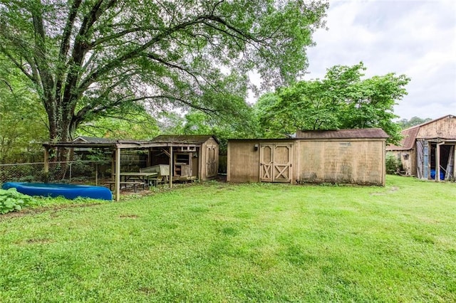 view of green lawn with a storage shed and an outdoor structure