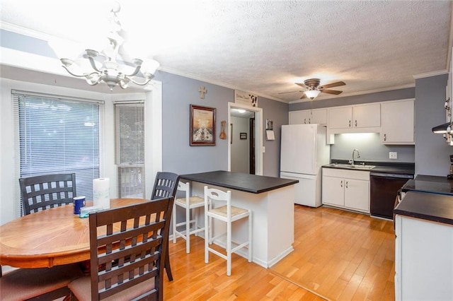 dining space with a chandelier, a ceiling fan, crown molding, light wood finished floors, and a textured ceiling
