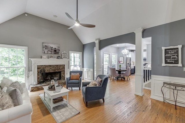 1045 Legacy Walk, Woodstock, GA 30189 - living room featuring light wood finished floors, high vaulted ceiling, a ceiling fan, ornate columns, and wainscoting