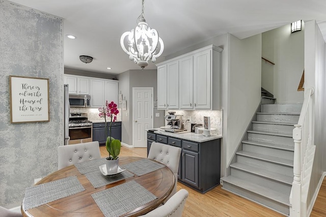 1045 Legacy Walk, Woodstock, GA 30189 - dining room featuring a chandelier, stairs, recessed lighting, and light wood-style floors