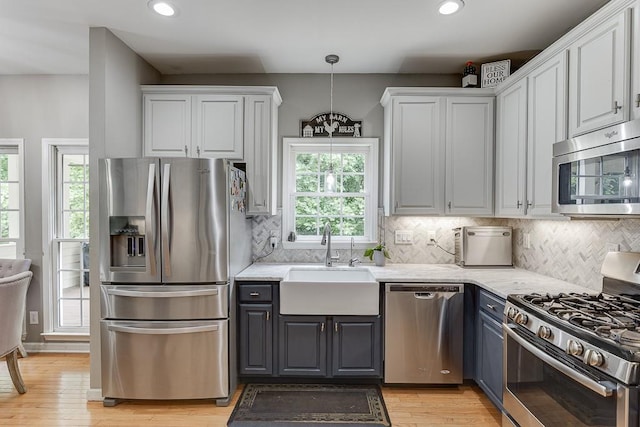 1045 Legacy Walk, Woodstock, GA 30189 - kitchen with appliances with stainless steel finishes, a sink, white cabinetry, recessed lighting, and light wood-style floors