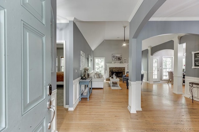 1045 Legacy Walk, Woodstock, GA 30189 - entryway featuring a stone fireplace, plenty of natural light, arched walkways, light wood-style floors, and vaulted ceiling