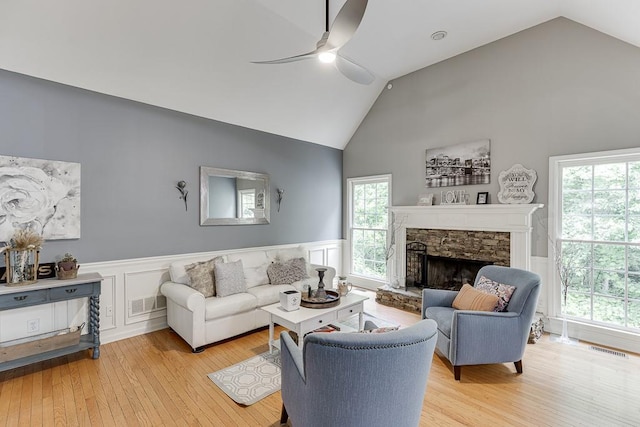 1045 Legacy Walk, Woodstock, GA 30189 - living room with wainscoting, ceiling fan, light wood finished floors, a fireplace, and high vaulted ceiling