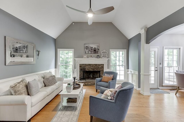 1045 Legacy Walk, Woodstock, GA 30189 - living area featuring arched walkways, light wood-style flooring, a wainscoted wall, a ceiling fan, and plenty of natural light