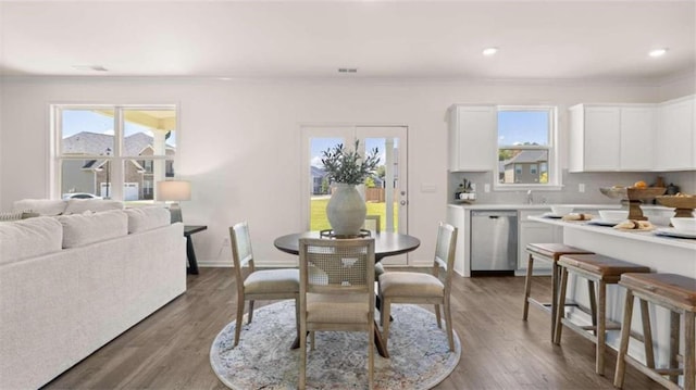 dining room with dark hardwood / wood-style floors and a healthy amount of sunlight