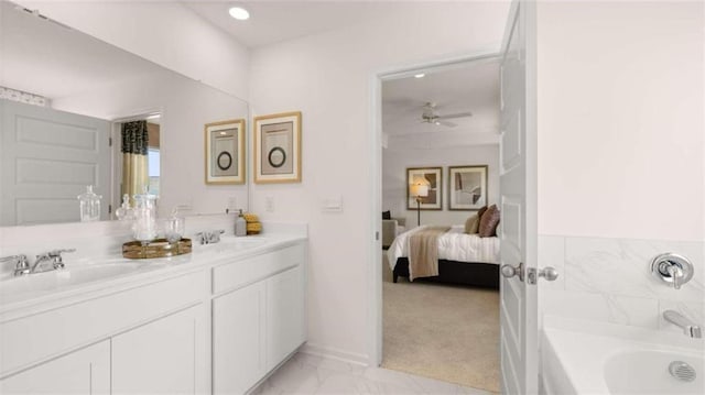 bathroom with vanity, ceiling fan, and a bath