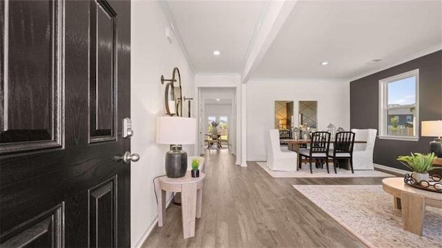 foyer with ornamental molding and light wood-type flooring