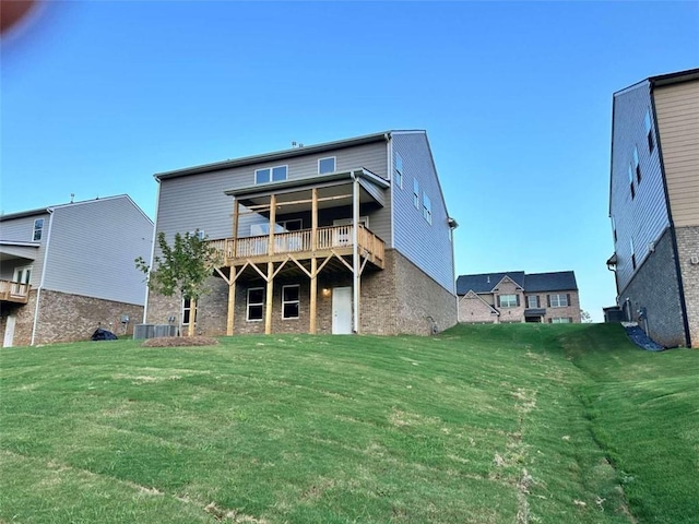 rear view of property with a yard, a balcony, and central AC