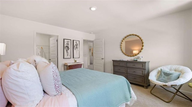 bedroom featuring a closet, a spacious closet, and light carpet