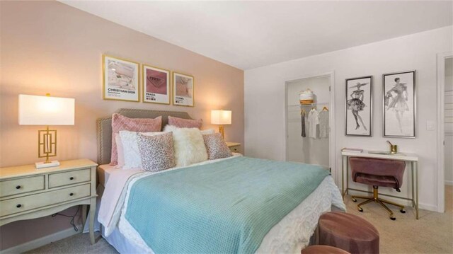 bedroom with a walk in closet, light colored carpet, and a closet