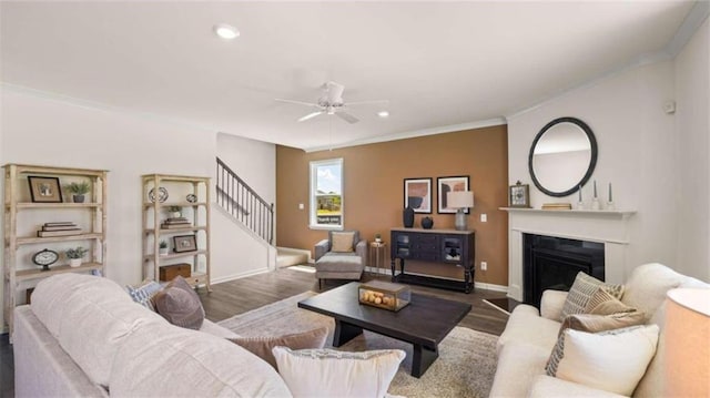 living room featuring ceiling fan, hardwood / wood-style flooring, and ornamental molding