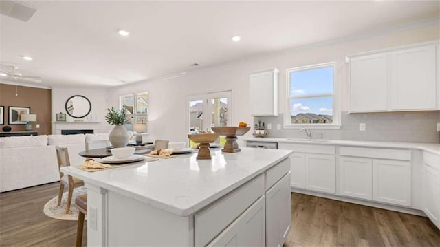 kitchen with a kitchen island, hardwood / wood-style flooring, and white cabinetry