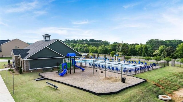 view of playground with a community pool and a lawn