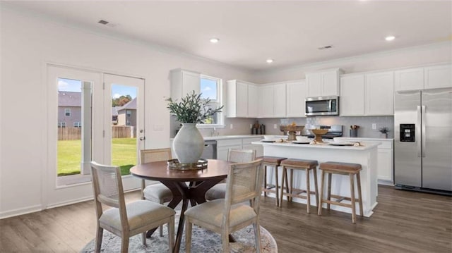 dining room featuring a wealth of natural light, dark wood-type flooring, and crown molding