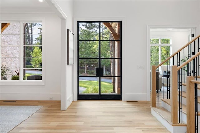 doorway with a healthy amount of sunlight and light hardwood / wood-style floors