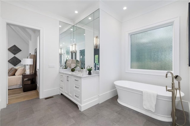 bathroom featuring vanity, crown molding, and a bath