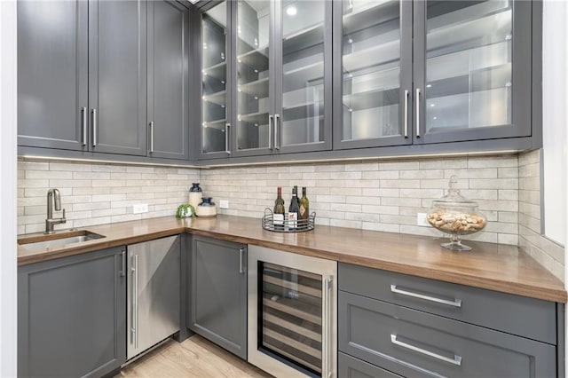 bar with gray cabinetry, butcher block counters, sink, and wine cooler