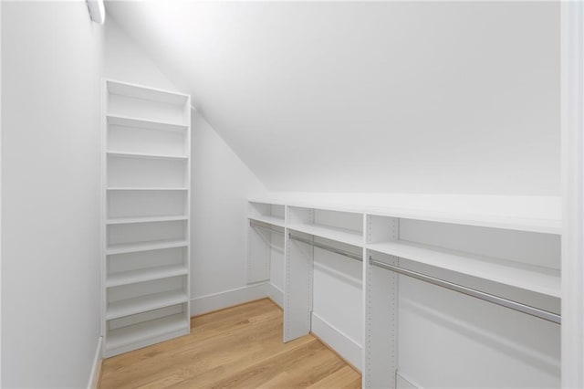 spacious closet featuring vaulted ceiling and light wood-type flooring