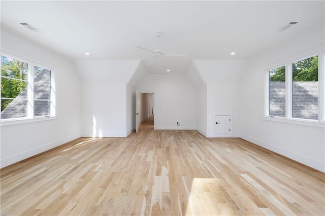 additional living space featuring ceiling fan, plenty of natural light, vaulted ceiling, and light hardwood / wood-style flooring