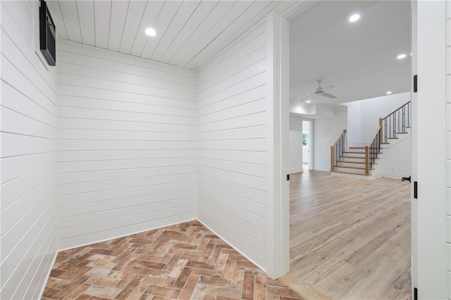 hallway featuring wooden walls