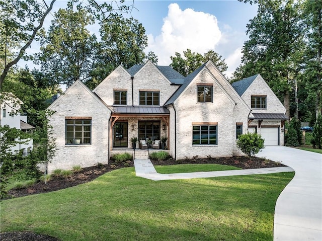 view of front of house with a porch, a garage, and a front yard