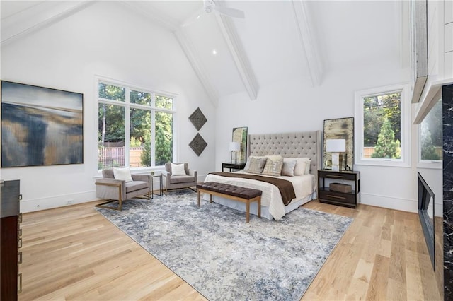 bedroom featuring multiple windows, light wood-type flooring, high vaulted ceiling, and ceiling fan