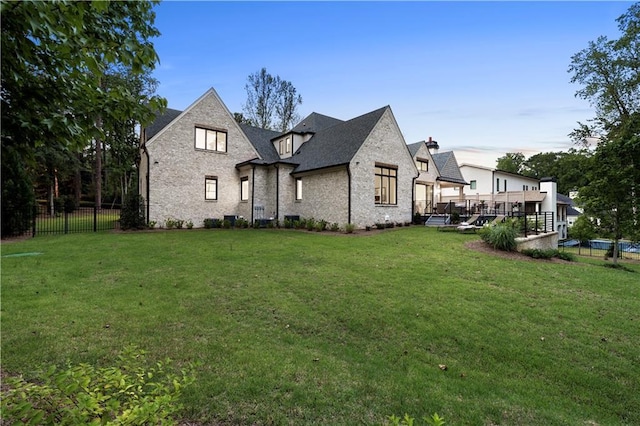 french country style house featuring a deck and a front yard