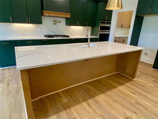 9224 Waldrip Rd, Gainesville, GA 30506 - kitchen with green cabinetry, light wood finished floors, a sink, stainless steel appliances, and tasteful backsplash