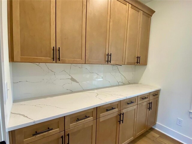 9224 Waldrip Rd, Gainesville, GA 30506 - kitchen featuring light stone counters, light wood-type flooring, backsplash, and baseboards