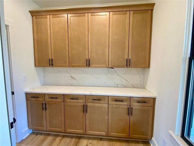 9224 Waldrip Rd, Gainesville, GA 30506 - kitchen featuring decorative backsplash, light stone counters, light wood-type flooring, and baseboards