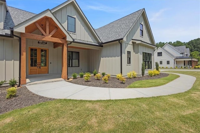 9224 Waldrip Rd, Gainesville, GA 30506 - view of front of property featuring board and batten siding, a front yard, a shingled roof, and french doors