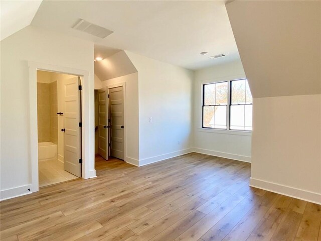 9224 Waldrip Rd, Gainesville, GA 30506 - unfurnished bedroom with lofted ceiling, light wood finished floors, baseboards, and ensuite bathroom