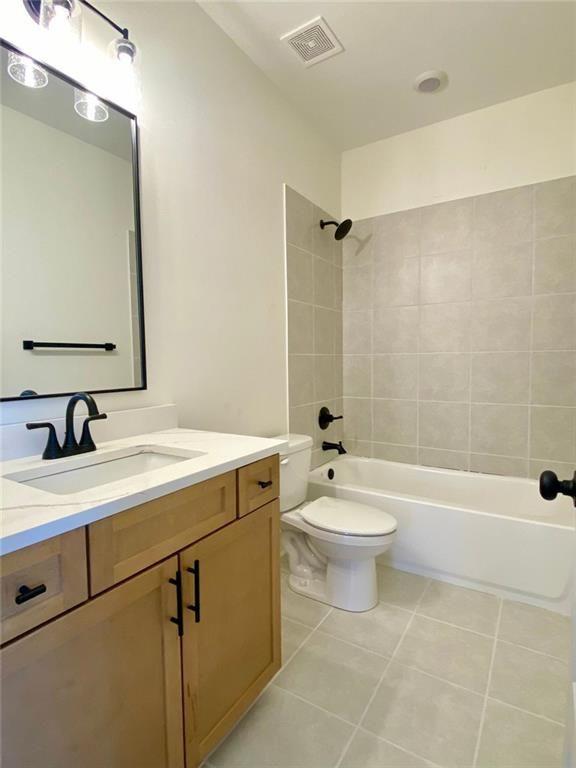 9224 Waldrip Rd, Gainesville, GA 30506 - bathroom featuring tile patterned flooring, vanity, toilet, and tub / shower combination