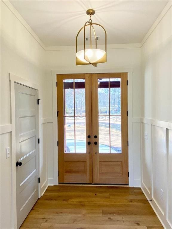 9224 Waldrip Rd, Gainesville, GA 30506 - entryway with french doors, a decorative wall, light wood-style floors, a wainscoted wall, and crown molding