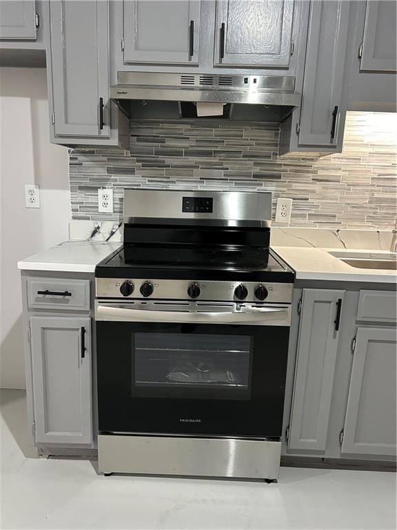 kitchen featuring electric stove, tasteful backsplash, and gray cabinetry