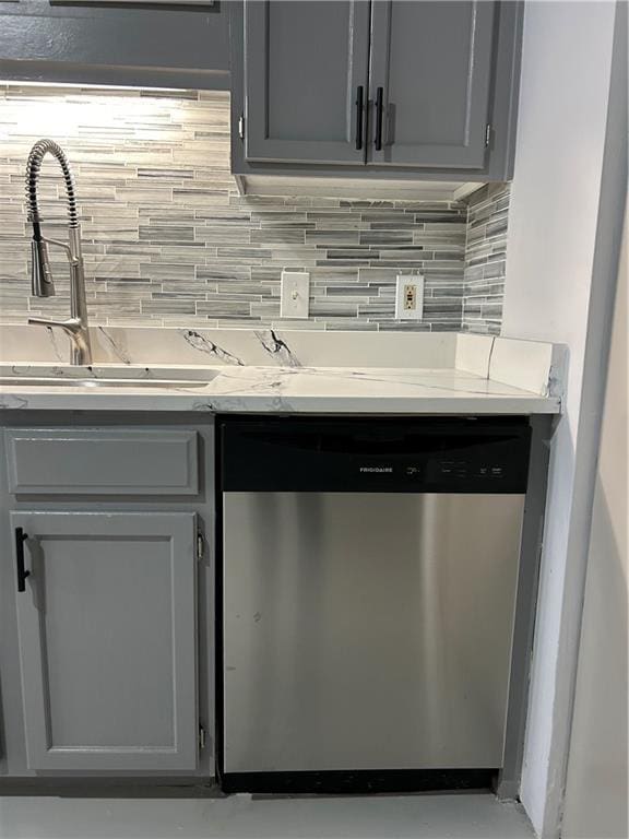 kitchen with tasteful backsplash, dishwasher, and gray cabinetry