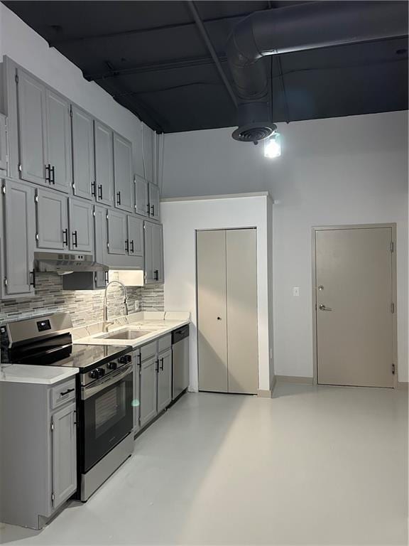 kitchen with sink, decorative backsplash, gray cabinets, and stainless steel appliances