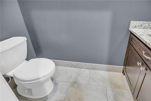 half bath featuring vanity, tile patterned floors, and toilet
