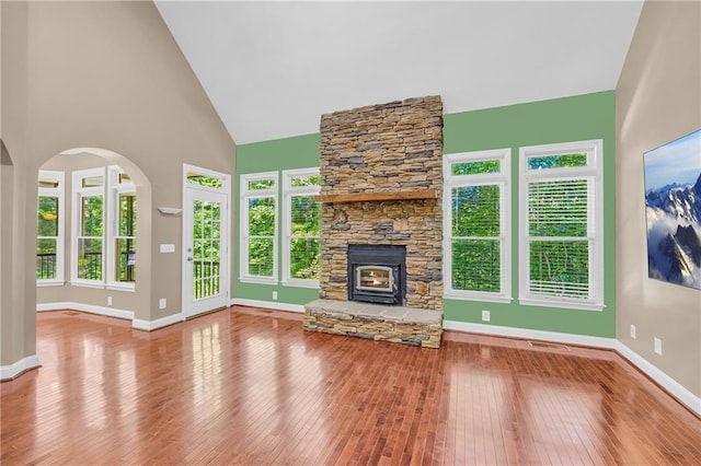 unfurnished living room featuring high vaulted ceiling, baseboards, and wood-type flooring