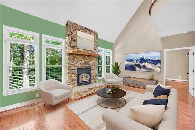 living area featuring baseboards, plenty of natural light, wood-type flooring, and visible vents