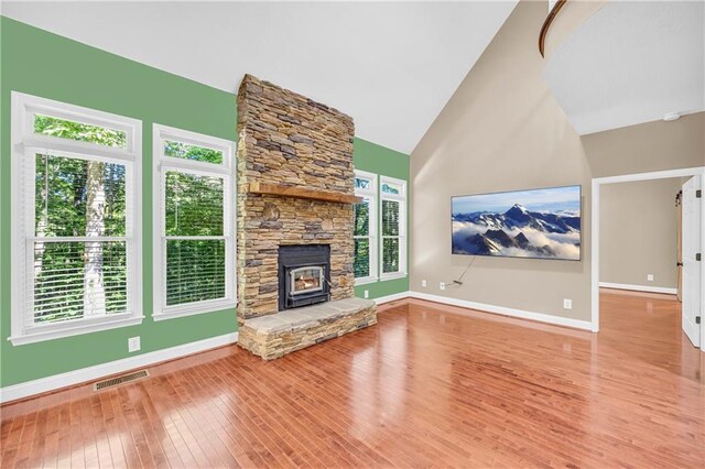 unfurnished living room with visible vents, baseboards, wood finished floors, and high vaulted ceiling